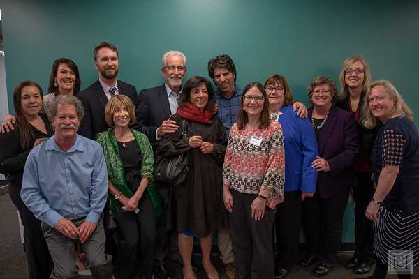Cindy Thomas, a white woman, smiling in a group with 12 other people from different backgrounds