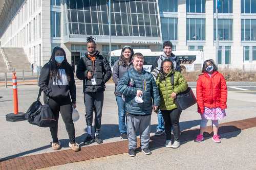 Group photo of MAICEI students and mentors in front of the UMass Boston campus center.